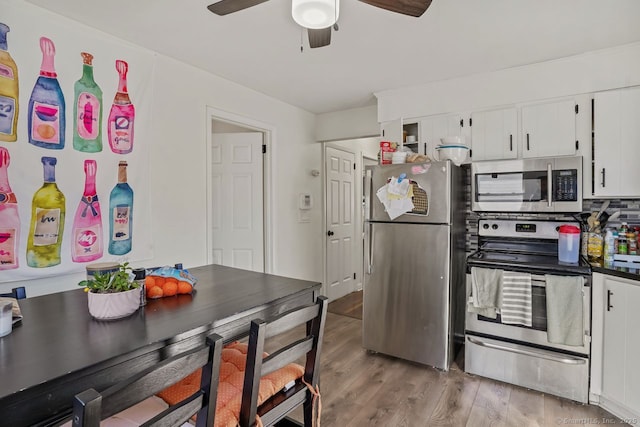 kitchen with white cabinetry, ceiling fan, stainless steel appliances, and hardwood / wood-style flooring