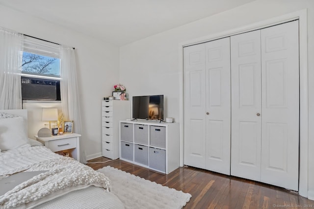 bedroom with a closet, cooling unit, and dark hardwood / wood-style floors