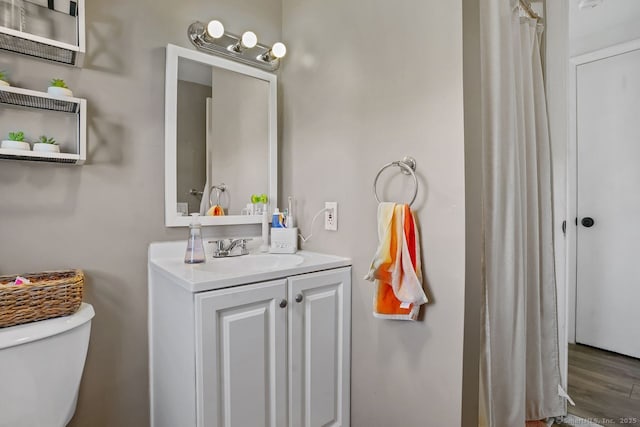 bathroom featuring hardwood / wood-style flooring, vanity, and toilet