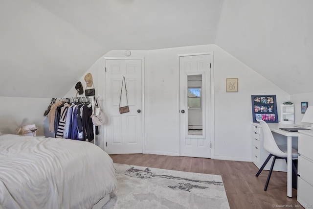 bedroom with lofted ceiling and light hardwood / wood-style flooring