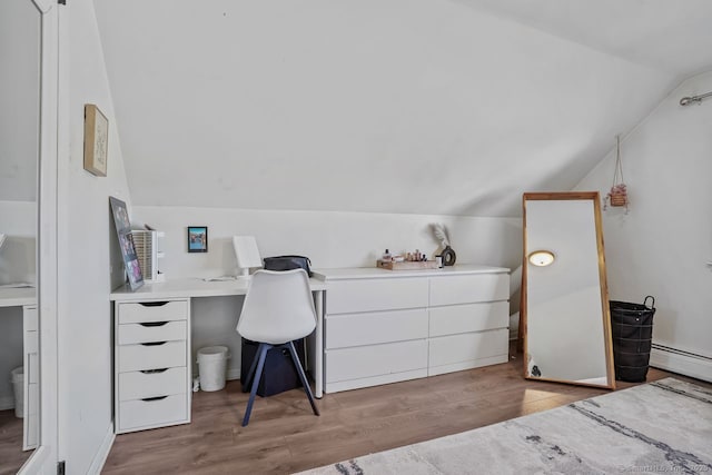 bedroom featuring a baseboard radiator, lofted ceiling, and light wood-type flooring