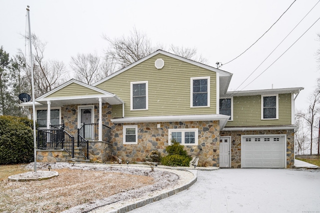 tri-level home with a porch and a garage