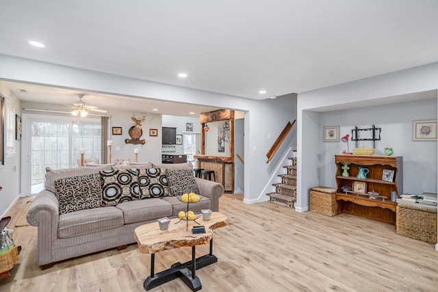 living room with ceiling fan and light wood-type flooring