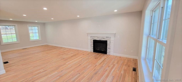 unfurnished living room with a fireplace and light wood-type flooring