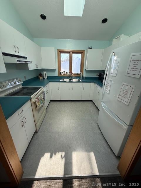 kitchen featuring white cabinets, a skylight, sink, and white appliances