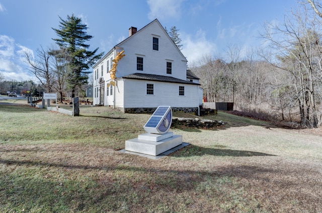 back of house featuring a lawn