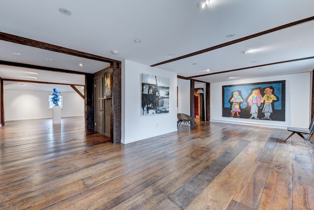 interior space with wood-type flooring and beam ceiling