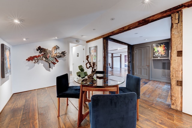 dining space with hardwood / wood-style floors and vaulted ceiling with beams