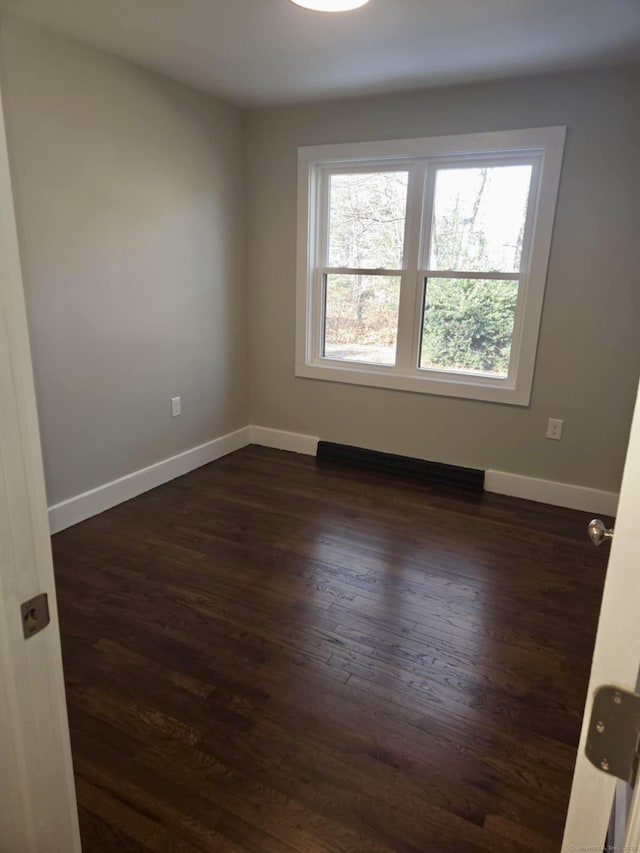 unfurnished room with dark hardwood / wood-style flooring