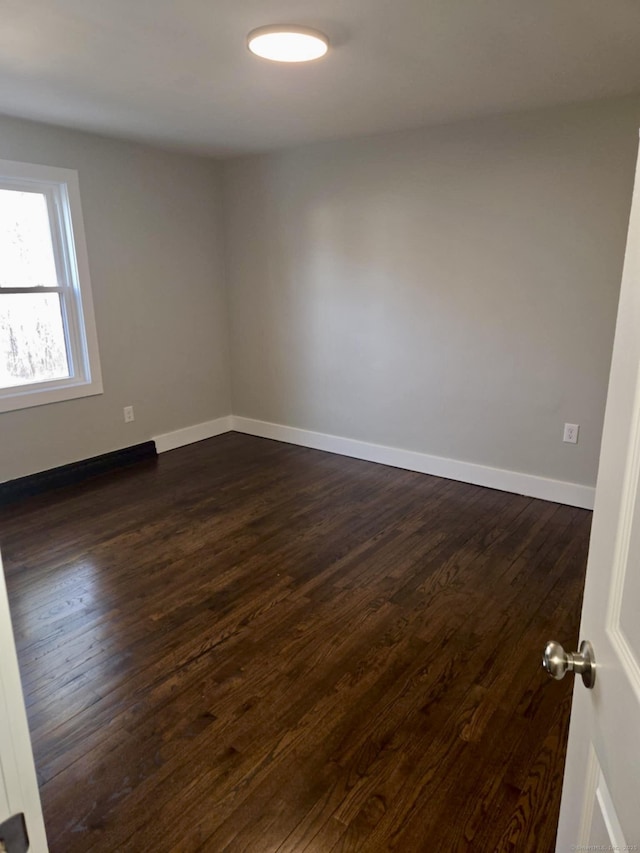 unfurnished room featuring dark wood-type flooring