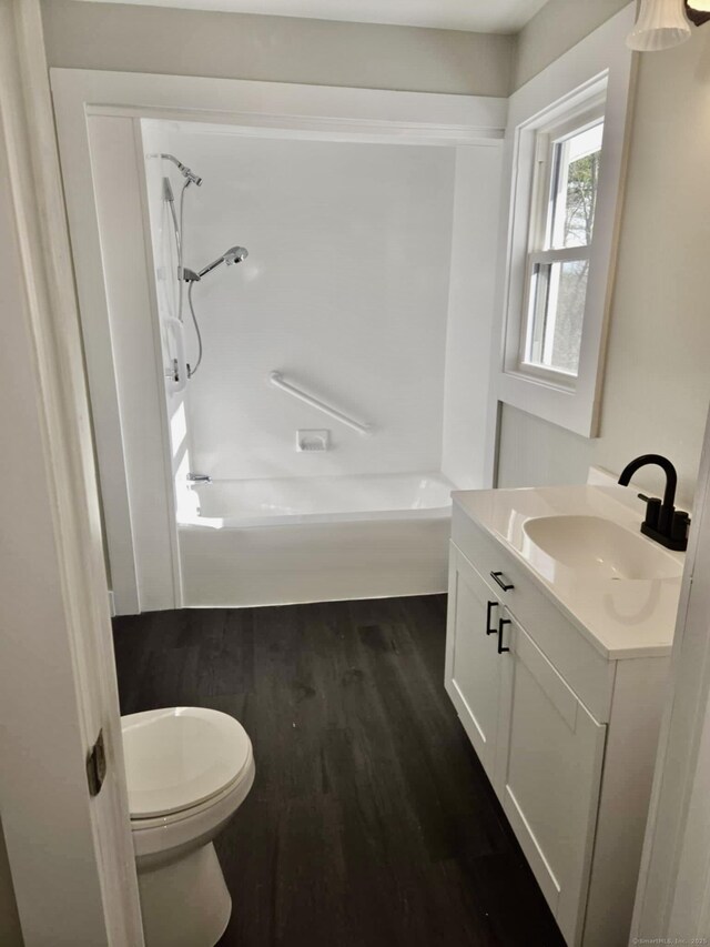 full bathroom with shower / tub combination, hardwood / wood-style floors, vanity, and toilet