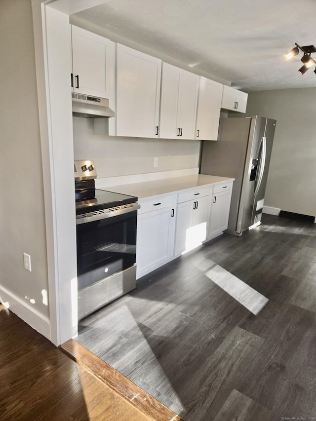 kitchen with appliances with stainless steel finishes, white cabinetry, and dark hardwood / wood-style floors