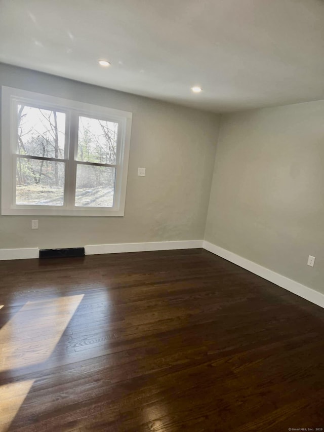 unfurnished room with dark wood-type flooring