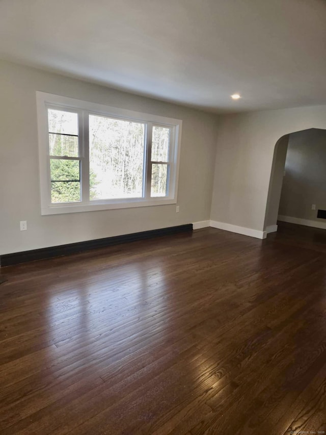 unfurnished room with dark hardwood / wood-style flooring and a wealth of natural light