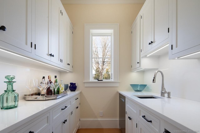 bar featuring white cabinetry, sink, and dishwasher