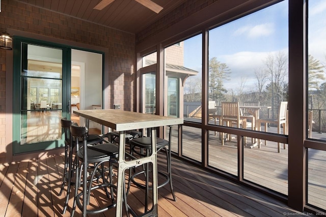 sunroom featuring ceiling fan and wood ceiling