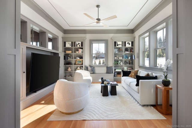 living area featuring ceiling fan, wood-type flooring, and ornamental molding