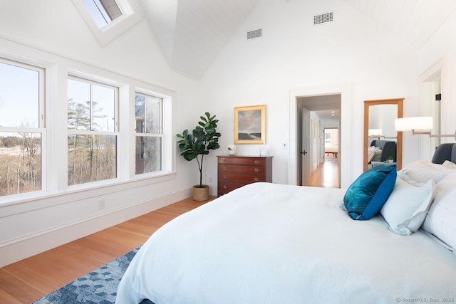 bedroom with high vaulted ceiling and wood-type flooring