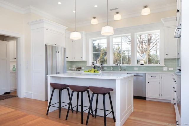 145 Taconic Rd, Salisbury, CT 06068 - kitchen featuring stainless steel appliances, a breakfast bar, decorative backsplash, light countertops, and ornamental molding
