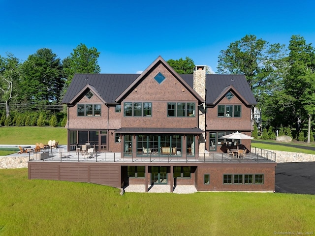 145 Taconic Rd, Salisbury, CT 06068 - back of property featuring a chimney, a lawn, a patio, and metal roof