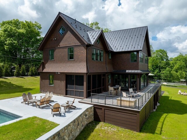 145 Taconic Rd, Salisbury, CT 06068 - rear view of house with a patio, a standing seam roof, a lawn, and metal roof