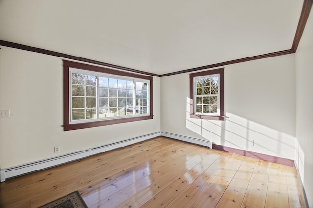 empty room featuring baseboard heating, light hardwood / wood-style floors, and ornamental molding