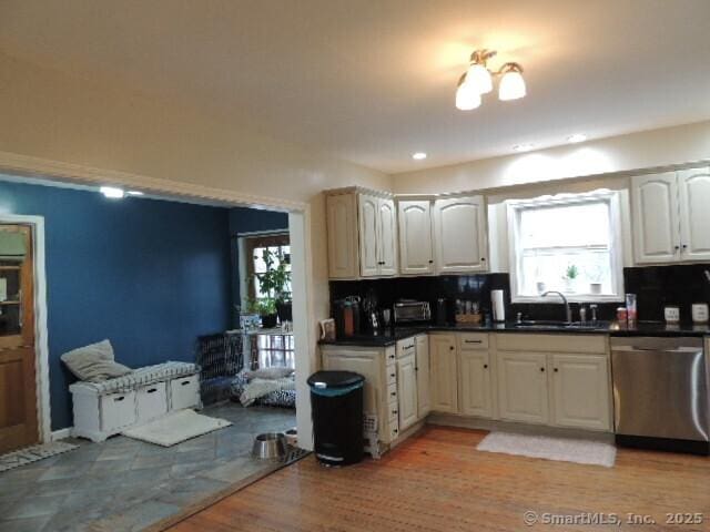 kitchen with tasteful backsplash, dishwasher, light hardwood / wood-style flooring, and sink