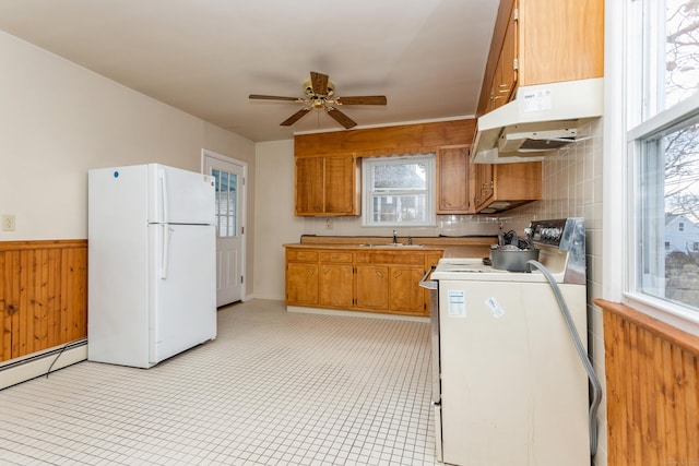 kitchen featuring stove, white refrigerator, sink, ceiling fan, and a healthy amount of sunlight