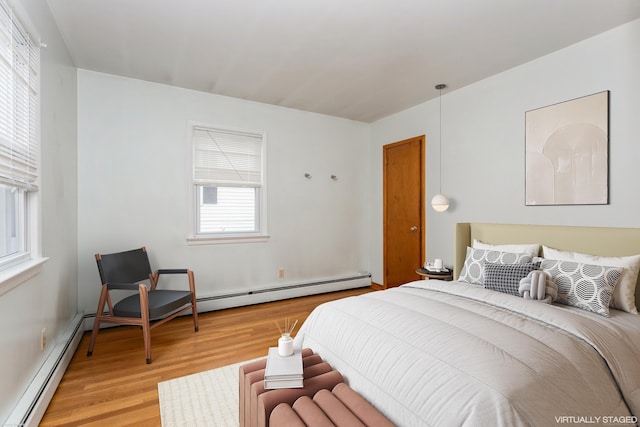 bedroom featuring light wood-type flooring and a baseboard radiator