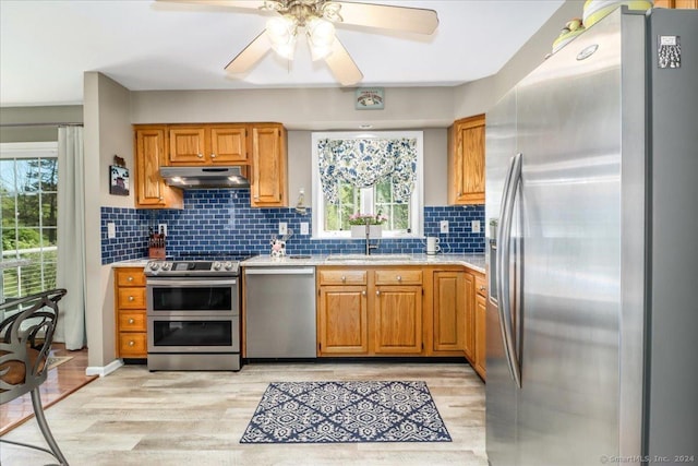 kitchen featuring a wealth of natural light, sink, light hardwood / wood-style floors, and appliances with stainless steel finishes