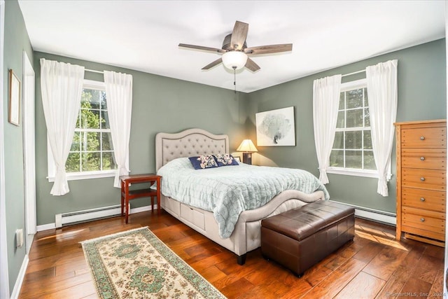 bedroom with ceiling fan, dark hardwood / wood-style flooring, and baseboard heating