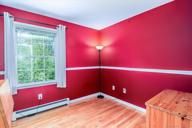 unfurnished room with wood-type flooring and baseboard heating