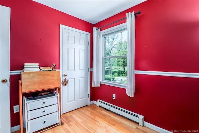 entryway with light wood-type flooring and a baseboard heating unit