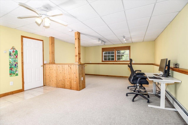 office with baseboard heating, ceiling fan, a drop ceiling, and light colored carpet