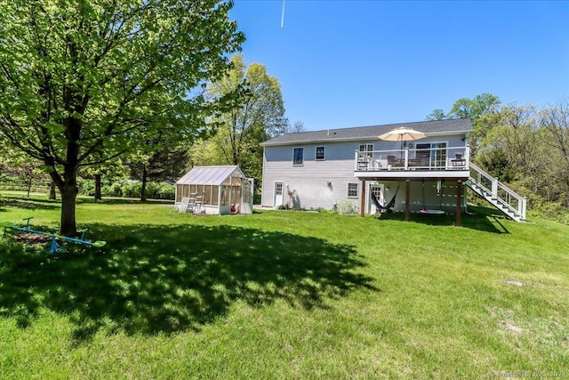 back of house with an outbuilding, a yard, and a wooden deck