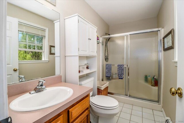 bathroom with tile patterned floors, toilet, an enclosed shower, and vanity