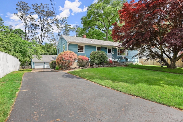 view of front of house with an outbuilding, a front lawn, and a garage