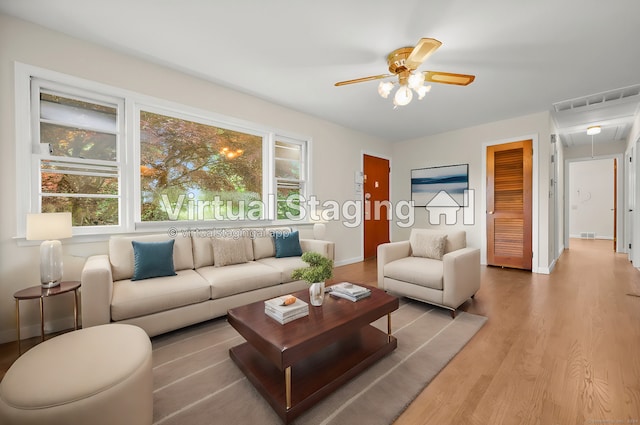 living room with plenty of natural light, light hardwood / wood-style floors, and ceiling fan