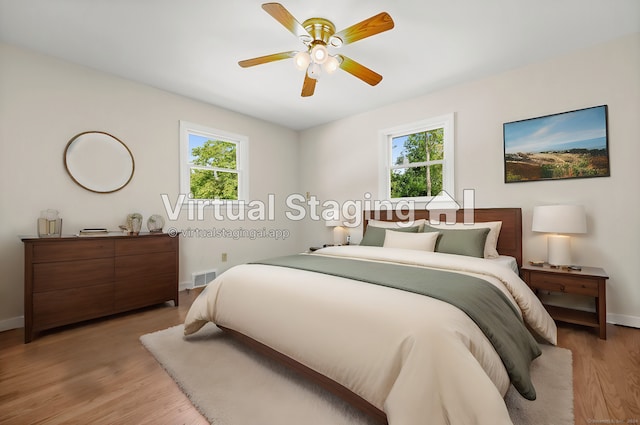 bedroom featuring multiple windows, light hardwood / wood-style flooring, and ceiling fan