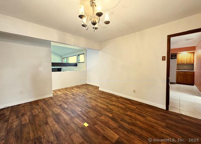 unfurnished dining area with dark hardwood / wood-style floors and a notable chandelier