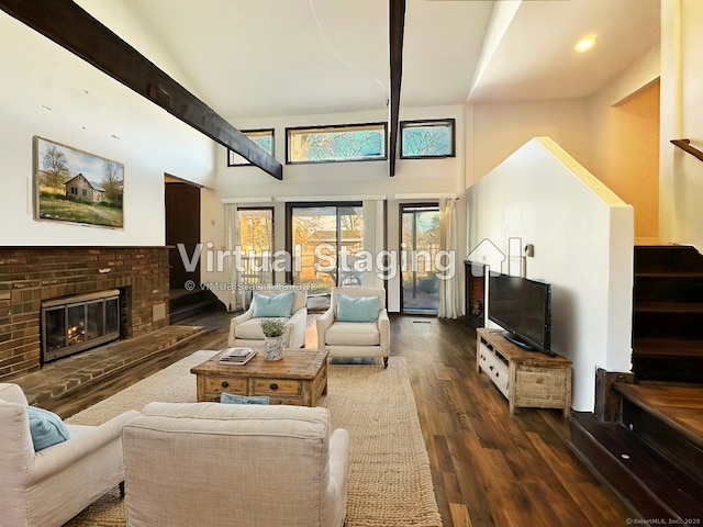 living room featuring a fireplace, a towering ceiling, and dark hardwood / wood-style floors