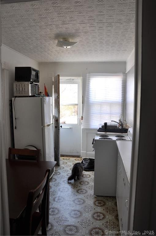 kitchen featuring white appliances and white cabinetry