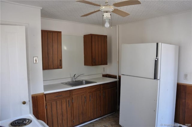 kitchen with ceiling fan, sink, a textured ceiling, and white refrigerator