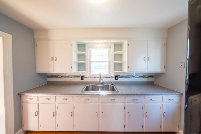 kitchen with white cabinets, sink, and tasteful backsplash