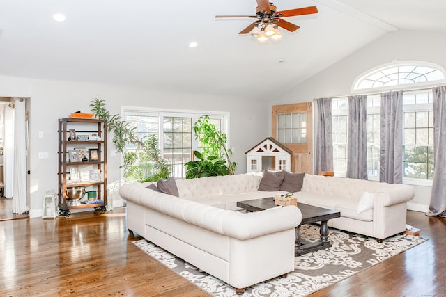 living room with hardwood / wood-style flooring, ceiling fan, and lofted ceiling with beams