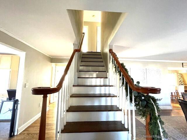 staircase featuring hardwood / wood-style flooring and crown molding