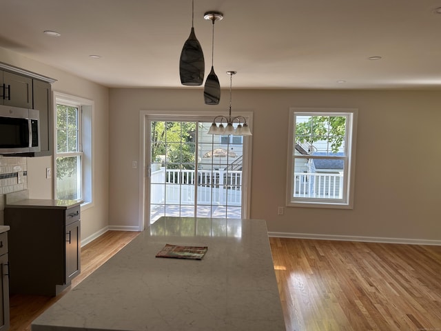 unfurnished dining area with light hardwood / wood-style flooring and a notable chandelier