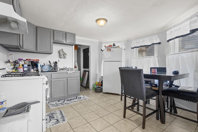 kitchen with white appliances, gray cabinets, ornamental molding, a textured ceiling, and light tile patterned flooring