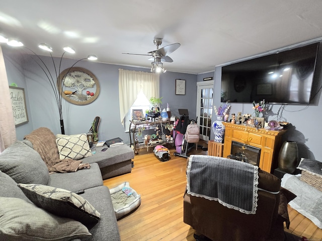 living room featuring ornamental molding, ceiling fan, and hardwood / wood-style floors