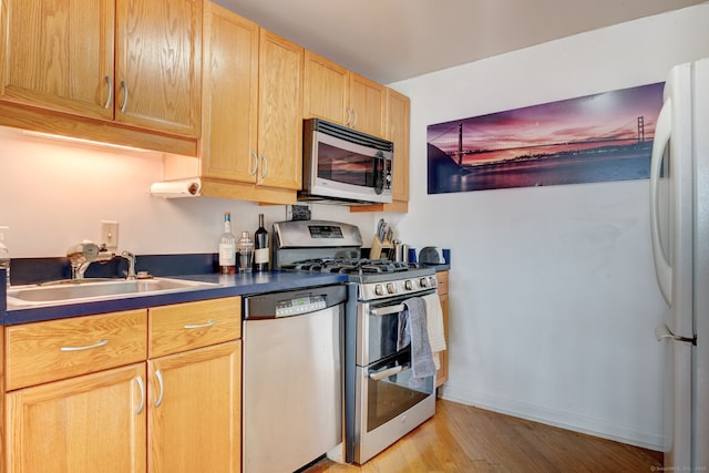 kitchen with light brown cabinetry, sink, stainless steel appliances, and light wood-type flooring